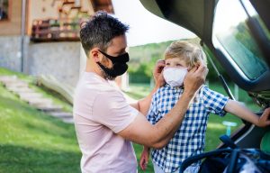 man putting mask on child